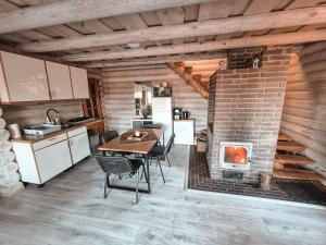 a kitchen and dining room with a brick fireplace at Poilsis netoli Druskininkų in Druskininkai