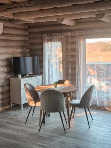 a dining room with a table and chairs and a television at Poilsis netoli Druskininkų in Druskininkai +15 photos