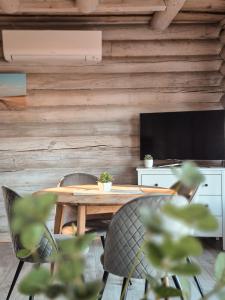 a dining room with a table and chairs and a television at Poilsis netoli Druskininkų in Druskininkai