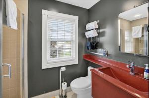 a bathroom with a toilet and a sink and a window at Globetrotters B&B in Niagara-on-the-Lake +33 photos