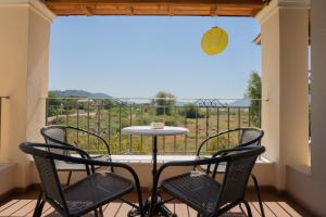a table and chairs on a balcony with a view at Alex house in Kouramaditika