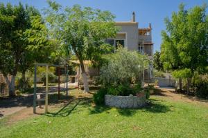 a house with a yard with trees and a swing at Alex house in Kouramaditika