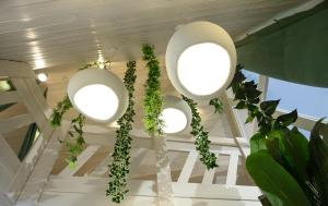 a hallway with three large white lights and plants at White DIAMOND in Chalkidiki in Vergia