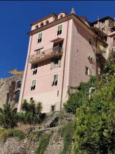 a pink building on the side of a hill at La Casa Rosa in Pigna