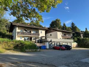 a house with two cars parked in front of it at Moderne Apartments im Bayerischen Wald mit Bergblick, Balkon & großer Terrasse in Schöfweg
