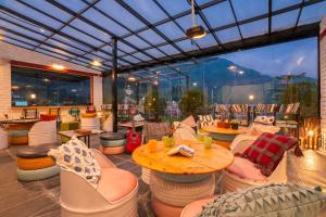 a restaurant with chairs and tables and a large window at PACK Mcleodganj in McLeod Ganj