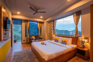 a bedroom with a large bed with a large window at PACK Mcleodganj in McLeod Ganj
