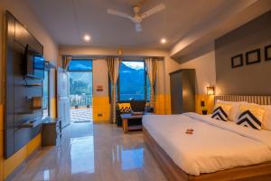 a bedroom with a large bed and a living room at PACK Mcleodganj in McLeod Ganj