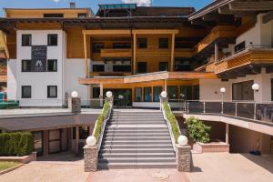 a building with a staircase in front of it at Saalbach Suites by ALPS RESORTS in Saalbach-Hinterglemm