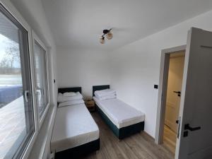 a small bedroom with two beds and a window at Kameralne Kładno in Łopienica