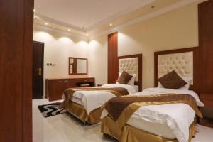 a hotel room with two beds and a mirror at Beauty Rayan 2 in Jazan