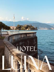 a sign for a hotel next to a body of water at Hotel Luina in Stresa