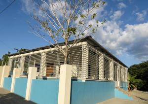 a building with a tree in front of it at Balbuena Countryside Villa with Private Pool in San Felipe de Puerto Plata