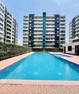 a swimming pool in front of some tall buildings at Urban Homes-Two Bedroom Near JKIA Airport in Nairobi