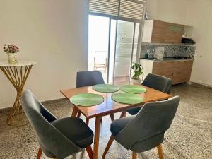 a dining room table with four green plates on it at APARTAMENTO COMPLETO, Piedra viva in Zapatoca