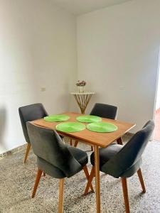 a dining room table with green plates on it at APARTAMENTO COMPLETO, Piedra viva in Zapatoca