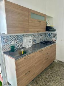 a kitchen with a sink and wooden cabinets at APARTAMENTO COMPLETO, Piedra viva in Zapatoca
