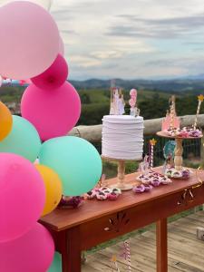 a birthday party with a cake and balloons at Pousada Recanto Namastê - Mandalah in Cunha +130 photos