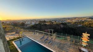 a swimming pool on top of a hill with a city at Pousada Recanto Namastê - Mandalah in Cunha