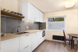 a kitchen with white cabinets and a table and a window at Central Apartment - Calm - No traffic in Stavanger