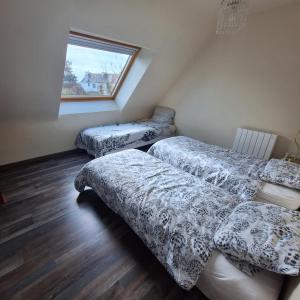 a bedroom with two beds and a window at Ty arvor in Saint-Pol-de-Léon