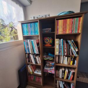 two book shelves filled with books next to a window at Ty arvor in Saint-Pol-de-Léon