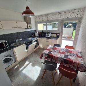 a kitchen with a table and some chairs and a table and a table at Ty arvor in Saint-Pol-de-Léon +7 photos