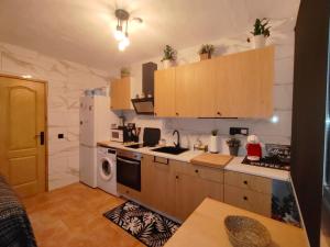 a kitchen with a refrigerator and a stove top oven at LAS TRES ROSAS in Vejer de la Frontera