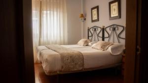 a bedroom with a large bed with white sheets at Hotel El Angliru in Cangas de Onís