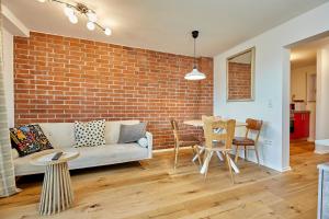 a living room with a couch and a brick wall at Moderne Apartments im Bayerischen Wald mit Bergblick, Balkon & großer Terrasse in Schöfweg