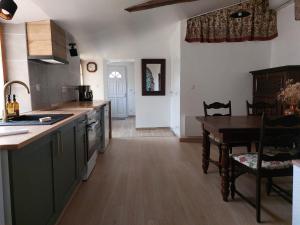 a kitchen with a table and a dining room at La Tanière du Renard in Vallet