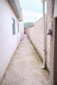 an alley between two buildings with a white wall at Ambiente familiar em Poços de caldas in Poços de Caldas