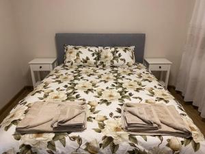 a bed with white flowers on it with towels on it at Яни Хоум in Gabrovo