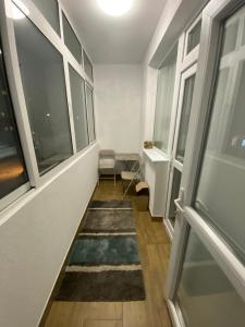 a hallway with a rug on the floor and windows at Яни Хоум in Gabrovo