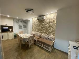 a living room with a table and a stone wall at Яни Хоум in Gabrovo +19 photos