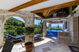 an outdoor patio with chairs and a swimming pool at Villa Strnj in Živogošće