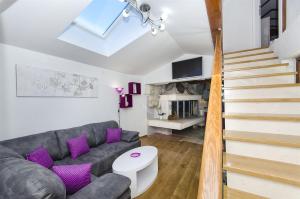 a living room with a grey couch and purple pillows at Villa Strnj in Živogošće