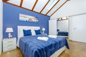 a blue bedroom with a bed with two pillows at Villa Strnj in Živogošće +36 photos