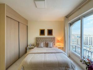 a bedroom with a large bed and a large window at Exquisite & inviting 2 Bedroom 2 bath Balcony Fast internet in Amman