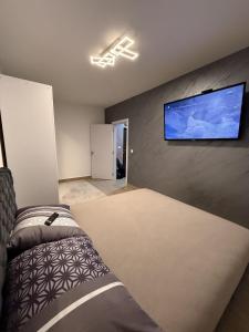a bedroom with a bed and a flat screen tv on the wall at Hil Obrenovac in Obrenovac
