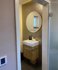 a bathroom with a sink and a mirror at TinyLoft in Bad Teinach-Zavelstein +27 photos