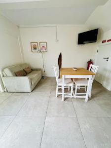 a living room with a table and chairs and a couch at Cantinho do Pópulo - Beach House in Ponta Delgada