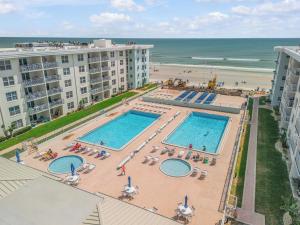 eine Luftaufnahme von zwei Swimmingpools und dem Strand in der Unterkunft Relaxing 1bd 1ba Condo - Ocean Front Complex in New Smyrna Beach in New Smyrna Beach