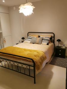 a bedroom with a bed with a yellow blanket on it at Maison Finchette pour 2 - 5 min Saint-Émilion - Terrasse privée - Parking - Arrivée autonome in Sainte-Terre