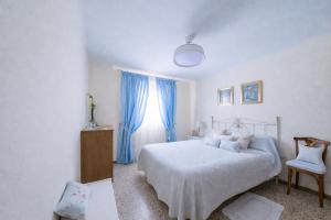 a bedroom with a bed and a window with blue curtains at Villa Campanilla in Olvera