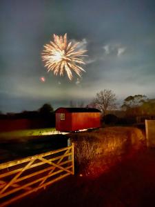 a red barn with a firework in the sky at Red Robin Retreat in Broadway