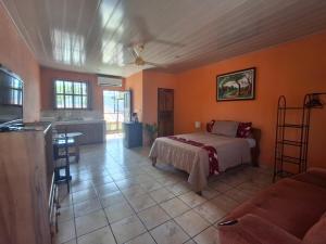 a bedroom with a bed and a kitchen with a table at Quepos Studio Apartments in Quepos