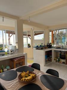 a kitchen with a table with a bowl of fruit on it at Versant Caraïbes in Gourbeyre