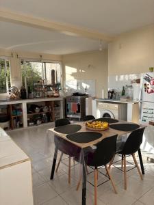 a kitchen with a table and chairs in a kitchen at Versant Caraïbes in Gourbeyre