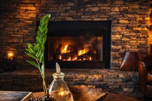 a fireplace with a fire burns in a table with a glass jar at Bella Vista! Long range MTN views, Hot Tub, Close to town and Lake in Blue Ridge